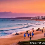 우루과이 해변 여행 - A vibrant coastal scene of Punta del Este beach during sunset, featuring the iconic "La Mano" sculpt...